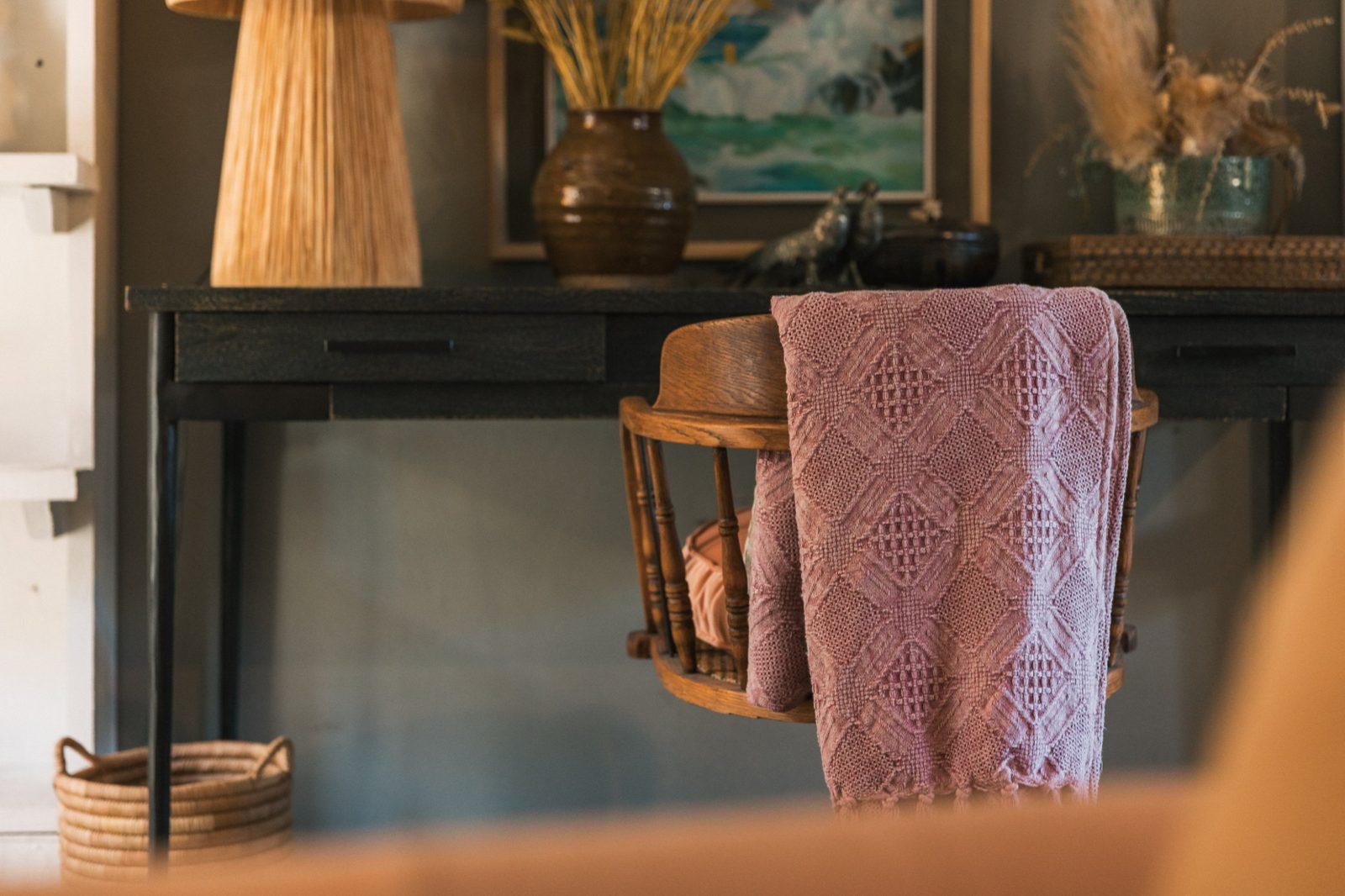 Pink knitted throw over a wooden chair